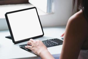 las mujeres de negocios usan una tableta para trabajar, una pantalla de tableta en blanco puede agregar texto u otros medios. foto