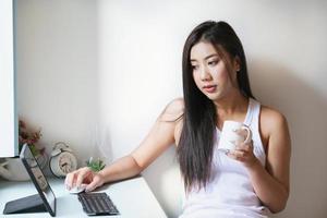 nueva normalidad, una mujer de negocios que usa una tableta para trabajar para una empresa a través de Internet en su escritorio en casa. foto