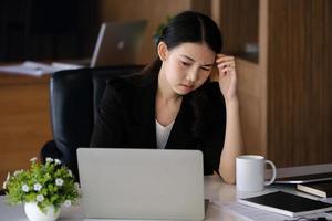 los empleados de la empresa muestran aburrimiento por el trabajo inconcluso usando computadoras portátiles, documentos y tabletas en el trabajo. foto