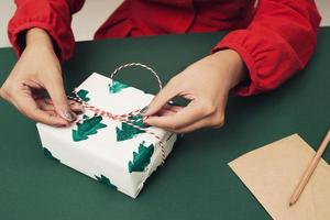 Woman wrapping present. Noel concept. photo
