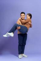 Young man holding girlfriend in his arms photo