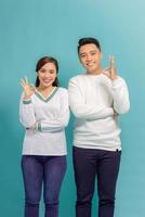 Beautiful, attractive, sexy smiling couple gesturing ok sign over blue background photo