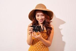 Woman traveler with a camera, beige background photo