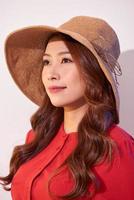 Blissful lady with broad smile posing in sunny day. Laughing girl in red clothes and trendy straw hat enjoying good weather in weekend. photo