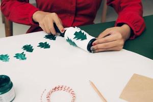 Woman making Christmas paper cover gift. Close up. Xmas concept. photo