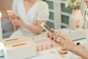 tractive  girl take selfie with a phone at the mirror with lamps in the beauty studio photo