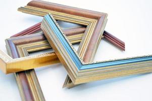 Samples of a wooden frame with an ornament lying on a light background. Picture frame corners photo