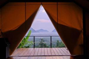 Stunning scenery view of tropical landscape looking from camping tent in foggy morning, beautiful Asia journey, natural unseen environment from the resort balcony, tranquil resting travel destination. photo