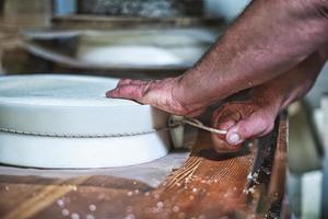 Tie of string to create the typical Italian Bergamasque cheese shape photo