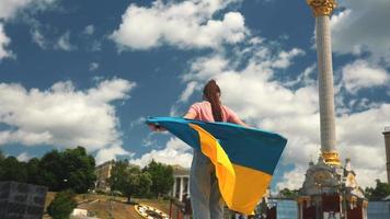 Young woman holds and waves flag of Ukraine in downtown Kyiv video