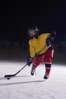 jugador adolescente de hockey sobre hielo en acción foto