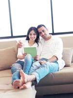 couple at modern home using tablet computer photo