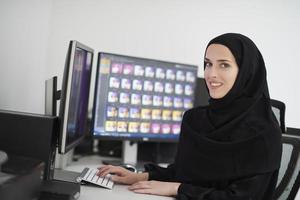 joven musulmana trabajando en la computadora desde casa foto