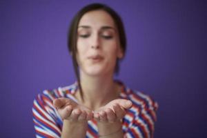 Close up portrait of charrming girl  blowing air kiss from open palm photo