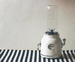 empty white vintage blender or smoothie maker on  black and white stripe table cloth and white wall. photo