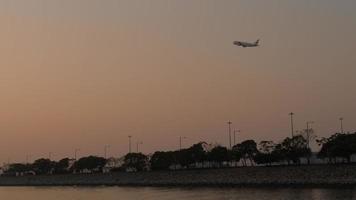 Airplane climbing in the air near Hong Kong Zhuhai Macao bridge in the vicinity of Hong Kong international airport, view from ferry boat. video