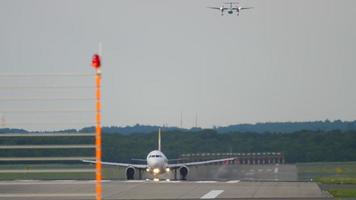 avión de pasajeros despegando de la pista mientras el avión turbohélice se acerca. aeropuerto de dusseldorf, alemania video