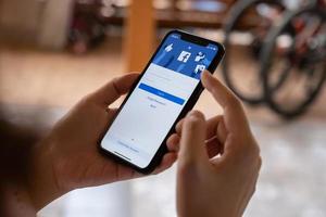 chiang mai, tailandia - 26 de febrero de 2020 mujer sostiene apple iphone xs con aplicación de facebook. facebook es una red social y el nombre de creación de criptomonedas es libra en 2019. foto