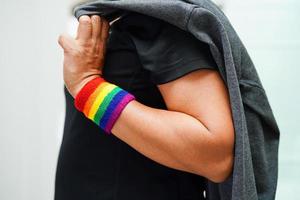 mujer asiática con bandera del arco iris, derechos de símbolos lgbt e igualdad de género, mes del orgullo lgbt en junio. foto