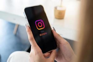 chiang mai, tailandia - 05 de marzo de 2022 una mujer que usa la aplicación instagram en iphone. carretes de instagram para hacer videos cortos de meta. foto