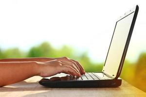 A man sitting at home typing information on a laptop Submit work to customers online. Concept of business technology photo