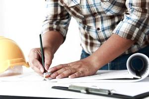 el técnico está escribiendo la construcción de edificios. en el escritorio de la oficina foto