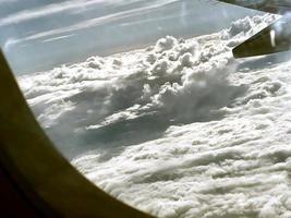 Clouds and sky view as seen through window of an aircraft photo