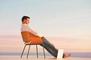 relaxed young man at home on balcony photo