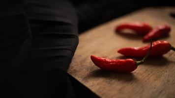 close up chili in the cutting board with black background texture photo