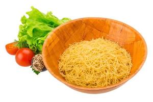 Raw pasta in a bowl on white background photo