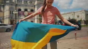 Young woman holds and waves flag of Ukraine in downtown Kyiv video