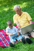 grandfather and child using laptop photo