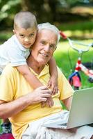 abuelo e hijo usando laptop foto