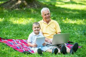 grandfather and child in park using tablet photo