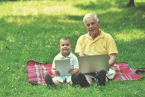 grandfather and child using laptop photo