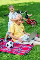 grandfather and child using laptop photo