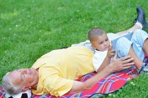 grandfather and child in park using tablet photo