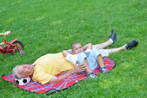 grandfather and child in park using tablet photo