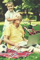 abuelo e hijo usando laptop