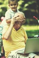 grandfather and child using laptop photo