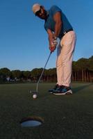 golfer  hitting shot at golf course photo