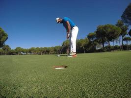 golf player hitting shot at sunny day photo