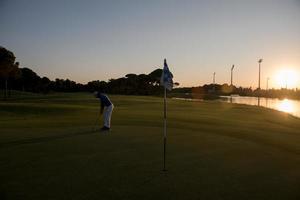 golfer hitting ball to hole photo