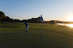 golfer hitting ball to hole photo