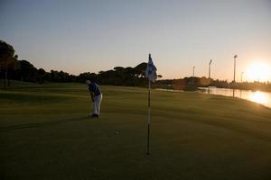 golfer hitting ball to hole photo