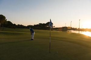 golfer hitting ball to hole photo