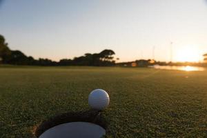 golf ball on edge of  the hole photo