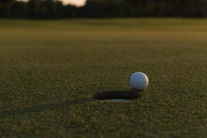 golf ball on edge of  the hole photo