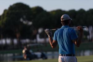 golfer from back at course looking to hole in distance photo