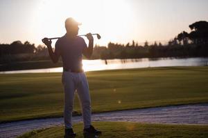 retrato de golfista en el campo de golf al atardecer foto